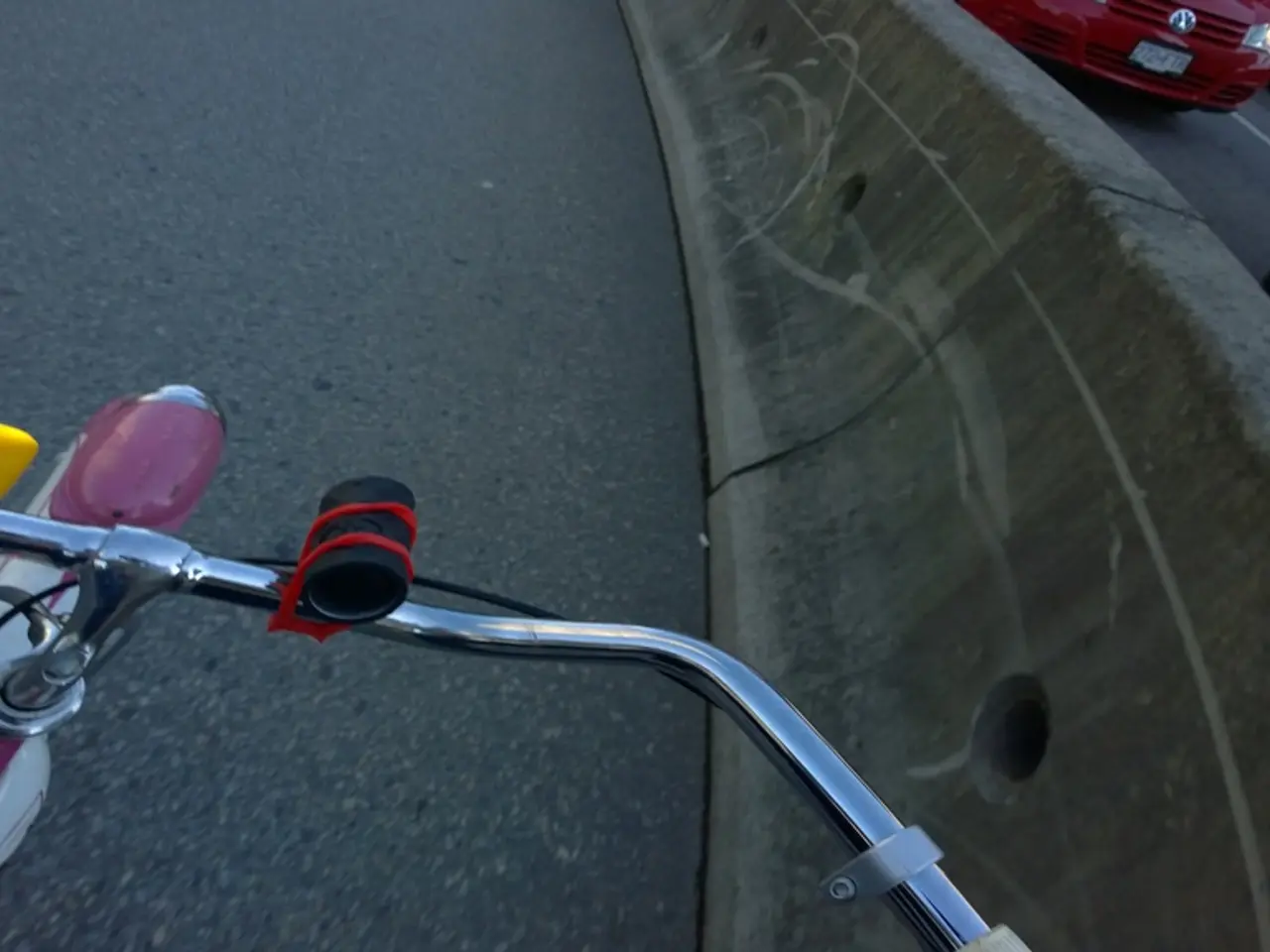 In this image I can see at the bottom it is the handle of a cycle. On the right side few vehicles...