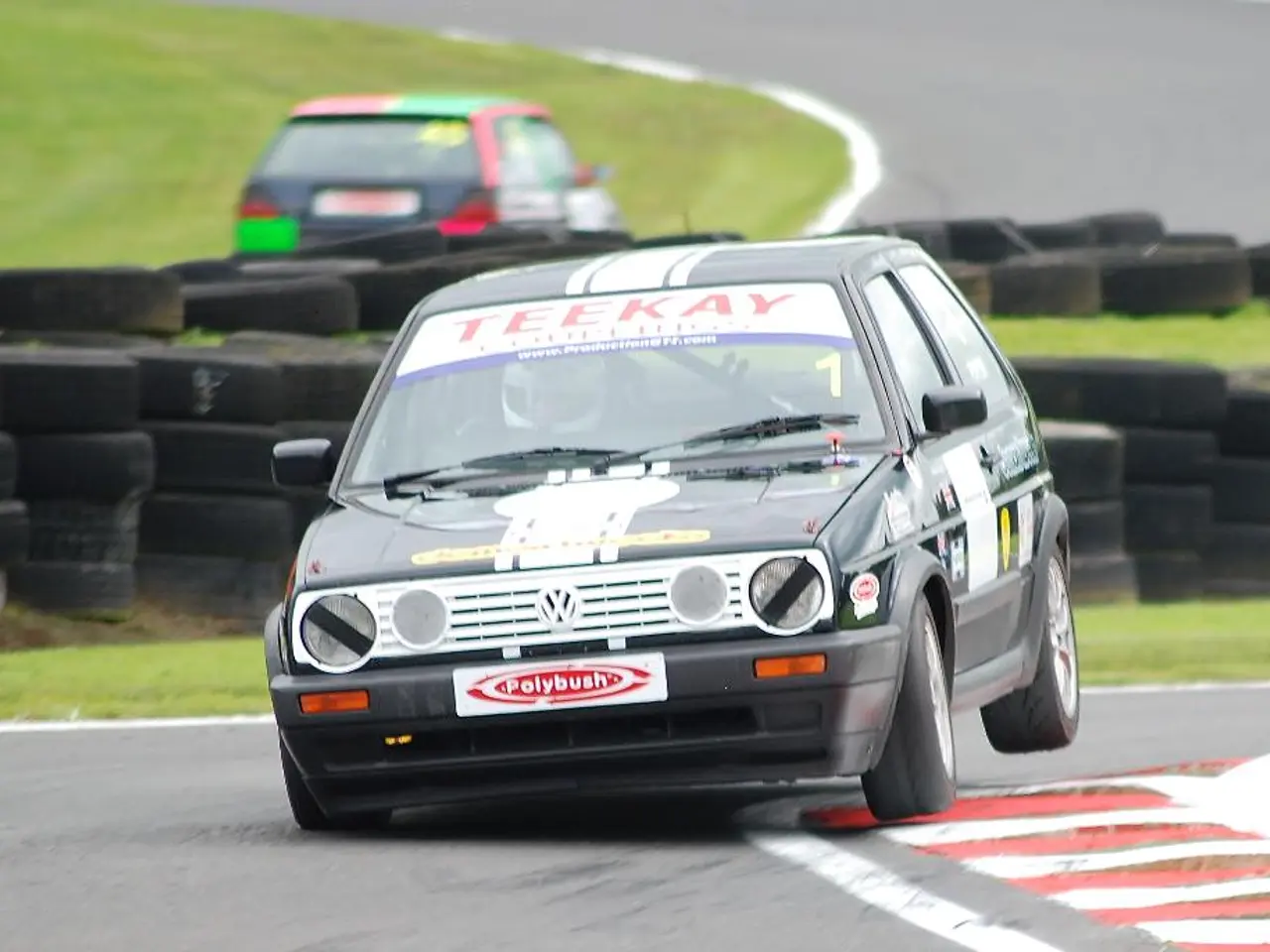 In this image, we can see some tires. There are cars in the middle of the image.