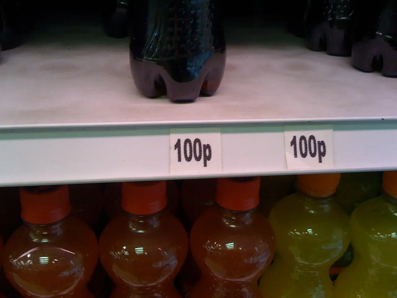In this image I see bottles, which are of orange, yellow and black in color and they are in racks...