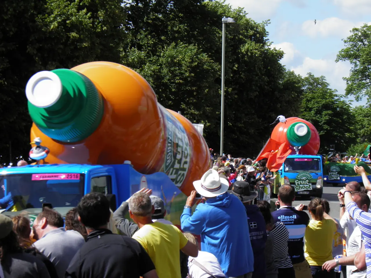 In the image there are trucks with huge bottle shaped tanks above it and many people standing on...