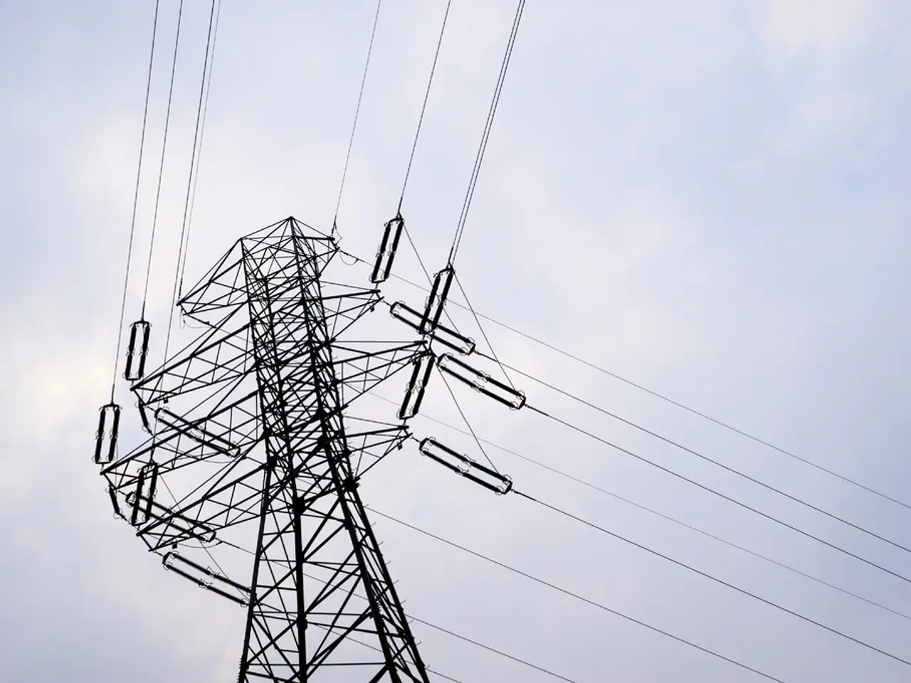 In this image I can see a antenna and there are some power lines visible and there is a sky...