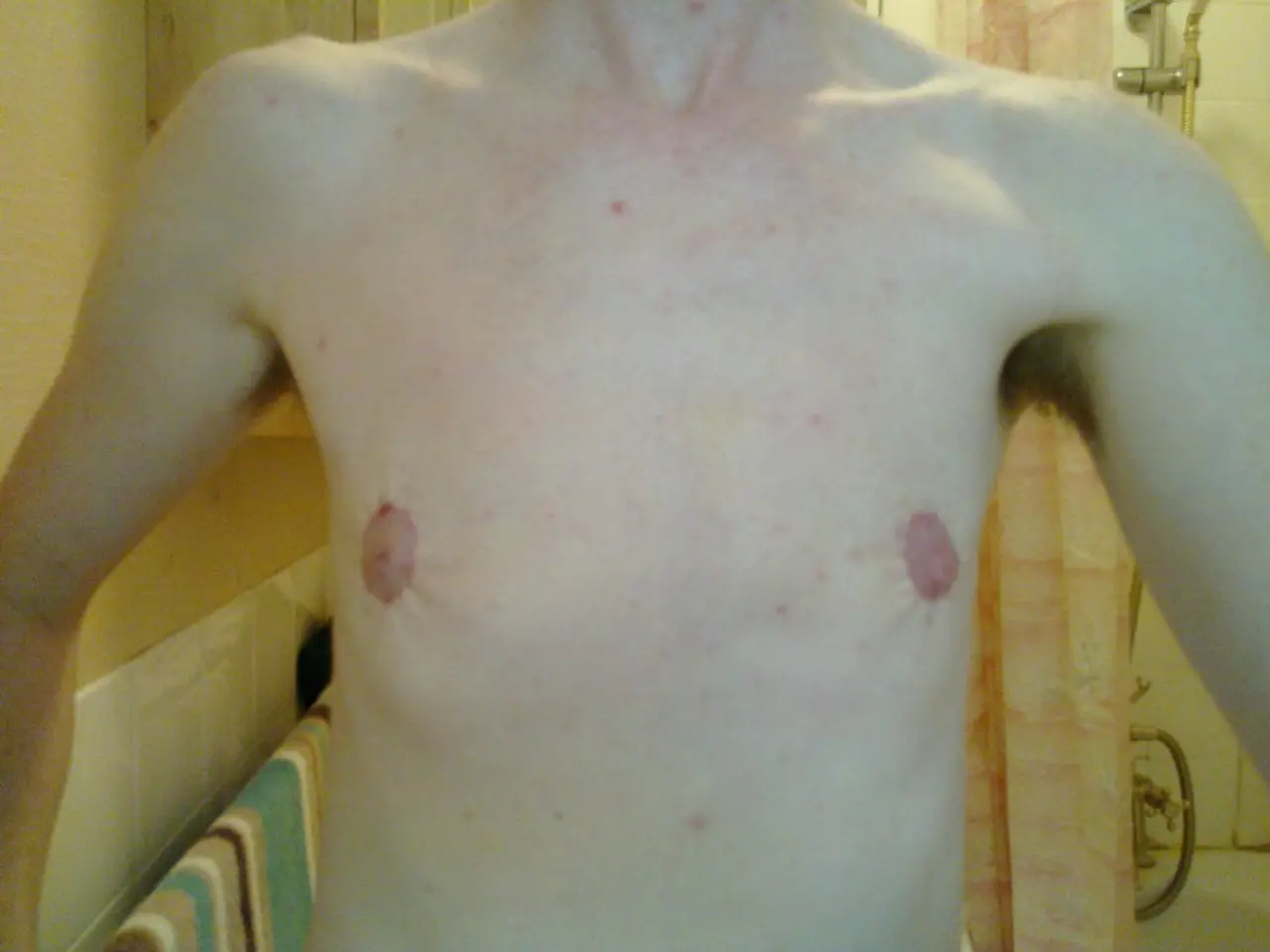 In this image I can see a person and in the background I can see few pipes.