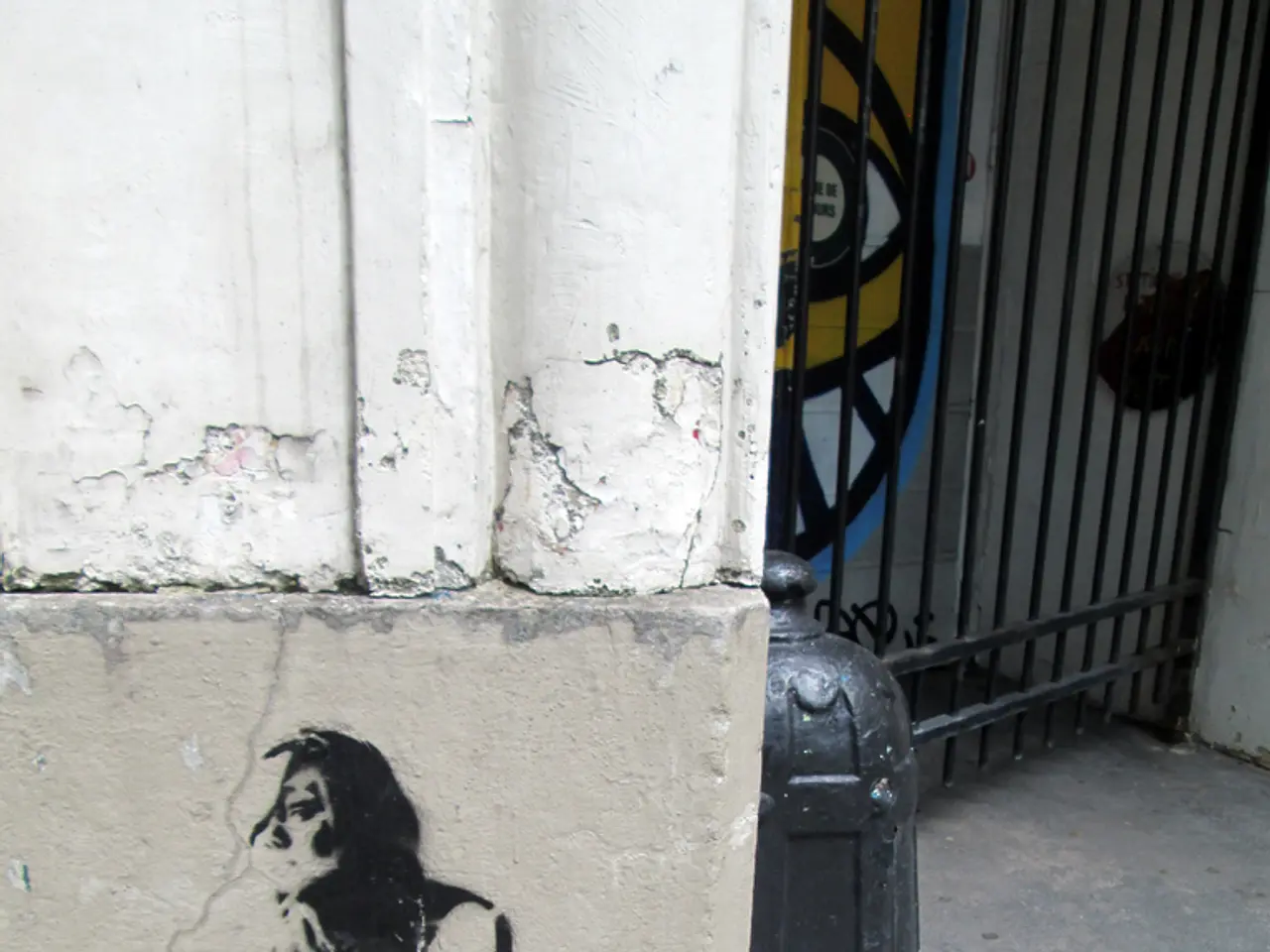 In this picture we can see a sketch on the wall. There is a gate on the right side.