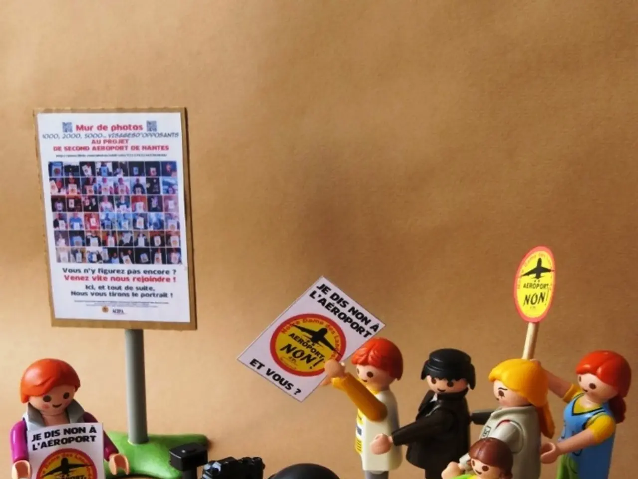 In this image we can see some toys which resembles like a human and there are few toys holding...