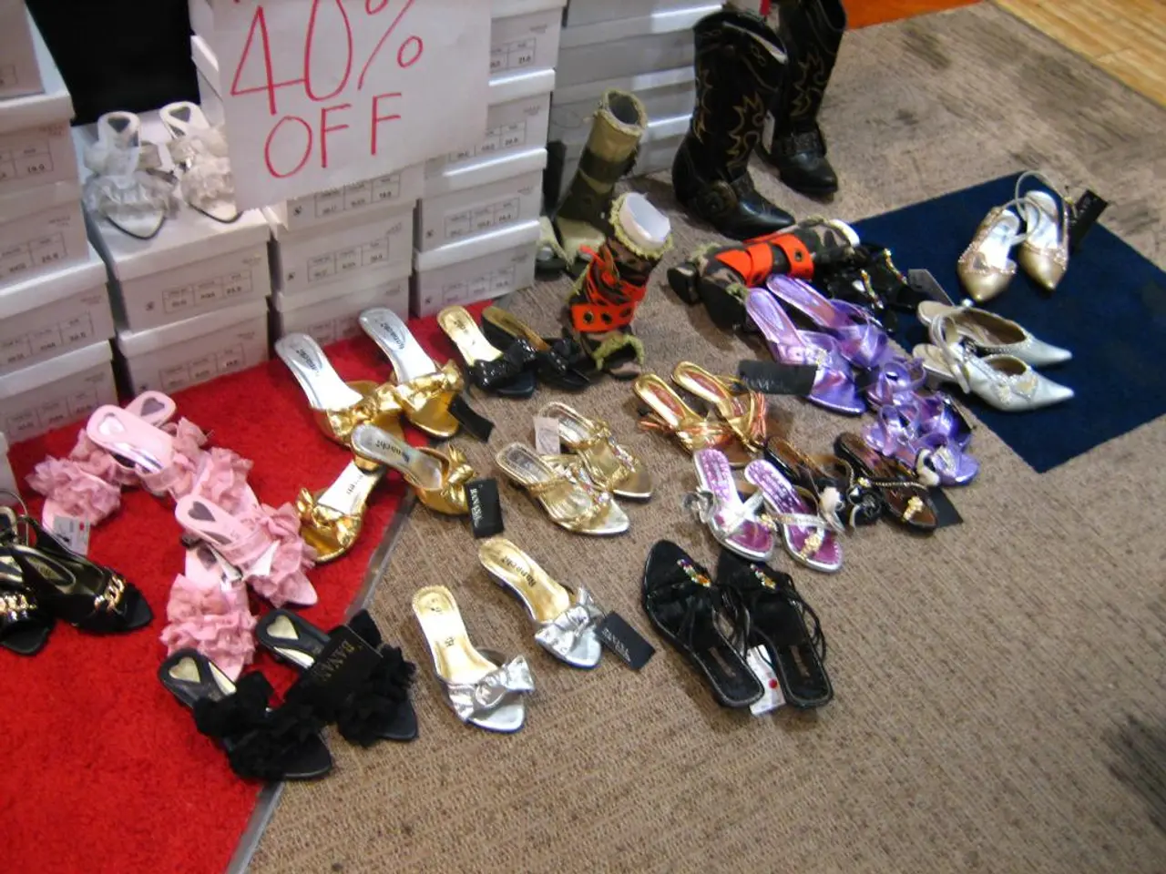 In this picture there are footwear in the center of the image, on the rug and there are boxes at...