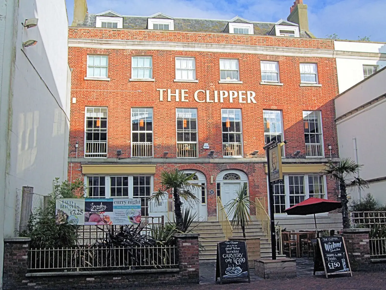 In the picture,it is a restaurant and there are many windows and two doors to the...