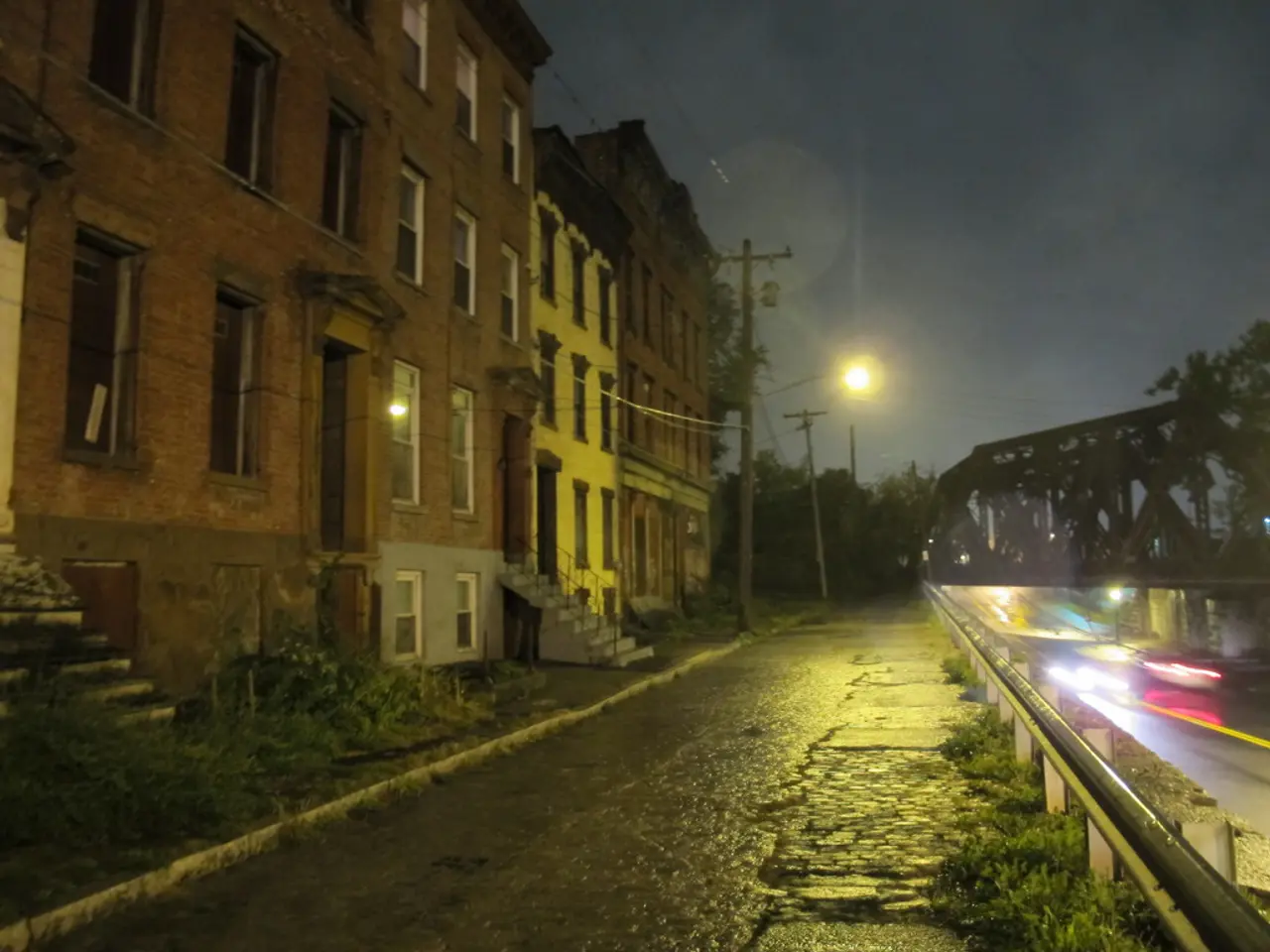 In this image there are buildings, in front of the buildings there are stairs with metal fence, in...