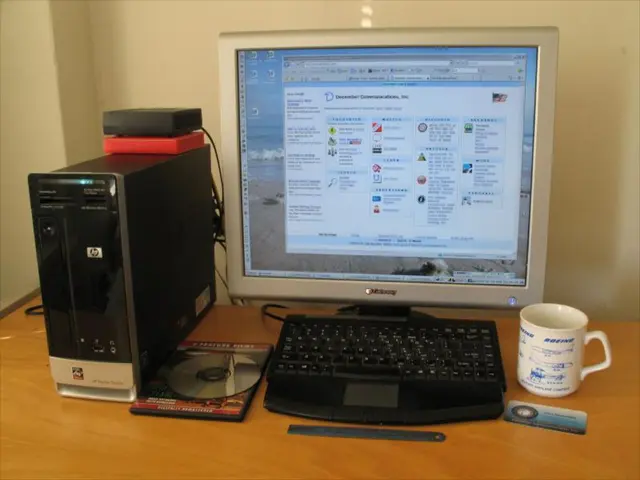 In the image we can see there is a table on which there is a monitor, mug, cpu, cd drive and blade.