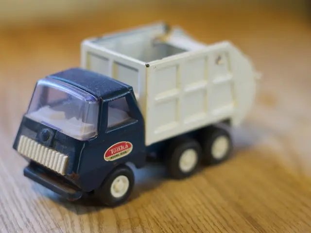 There is a toy vehicle present on a wooden floor as we can see in the middle of this image.