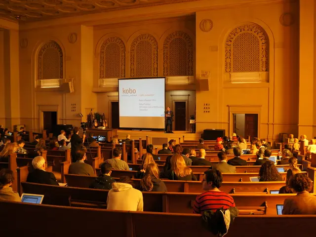 This image is clicked in a building. In this image we can see many persons sitting and using...