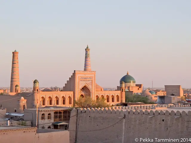 In this image I can see number of buildings, trees, wires and here I can see watermark.