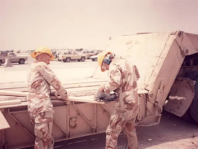 In the foreground of the picture I can see the truck on the road. I can see two men standing on the...