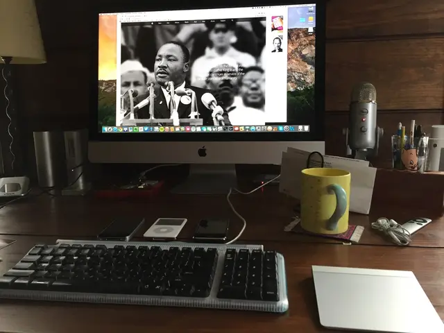 There are some electronic gadgets and a desktop on a table. In which a video clip is being played.